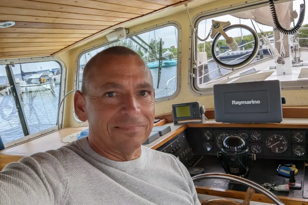 Steffen Albert im Steuerhaus eines Bootes im Hafen